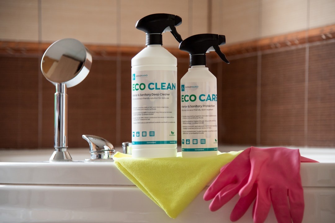 A pair of gloves and a sponge are sitting on a bathtub